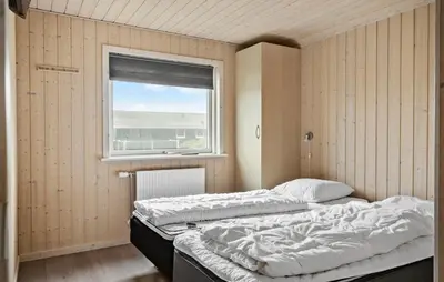 two beds in a room with a window at Cozy Home In Harboøre With Kitchen in Harboør