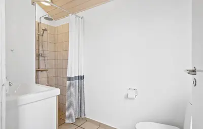 a white bathroom with a shower and a toilet at Cozy Home In Harboøre With Kitchen in Harboør
