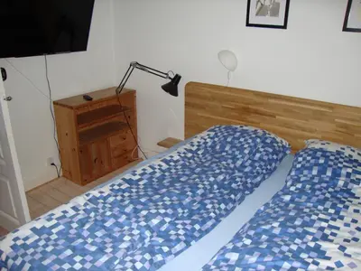 a bed with a blue comforter and a lamp in a bedroom at Klosterpensionen Annex in Viborg