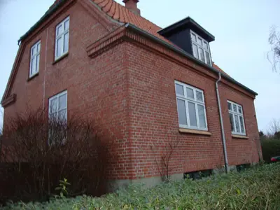 a red brick house with white windows on a hill at Klosterpensionen Annex in Viborg