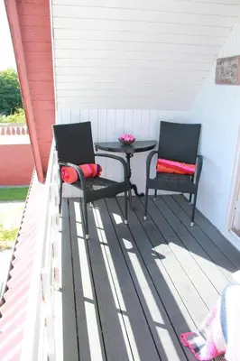 two chairs and a table on a porch at Tvillinggaard Thy in Vang