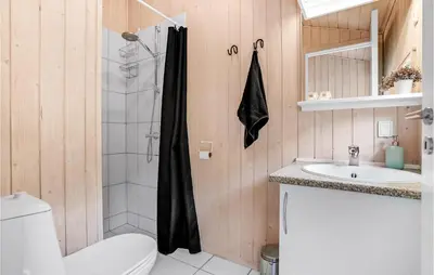 a bathroom with a shower and a toilet and a sink at Holiday Home Blokhus With Fireplace 05 in Blokhus