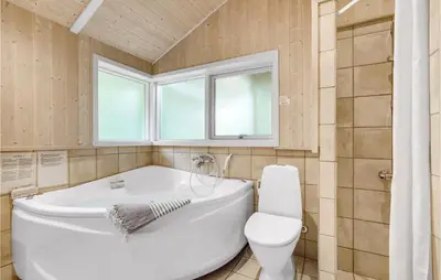 a bathroom with a white tub and a toilet at Holiday Home Vemb With Fireplace 07 in Vemb
