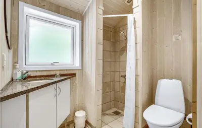 a bathroom with a toilet and a sink and a window at Holiday Home Vemb With Fireplace 07 in Vemb