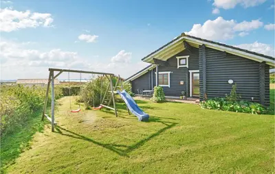 a playground with a slide in front of a house at Holiday Home Vinderup With Fireplace 07 in Vinderup