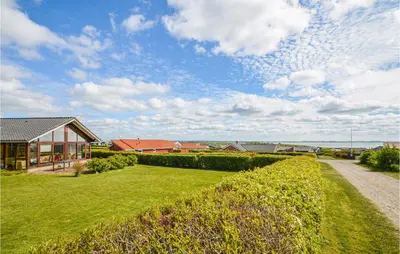 a house with a grassy yard next to a house at Holiday Home Vinderup With Fireplace 07 in Vinderup