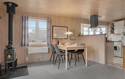 a kitchen with a table and chairs and a stove at Holiday Home Frøstrup With Fireplace 10 in Frøstrup