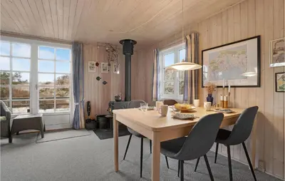 a dining room with a wooden table and chairs at Holiday Home Frøstrup With Fireplace 10 in Frøstrup