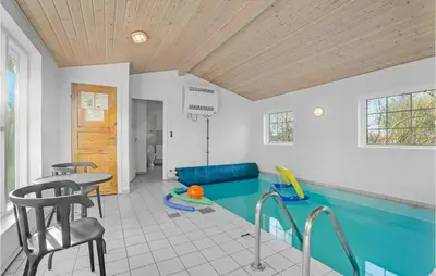 a swimming pool in a room with a table and chairs at Beautiful Home In Farsø With Kitchen in Farsø