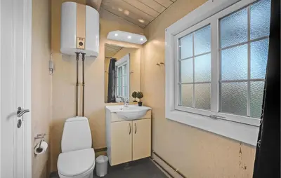 a bathroom with a toilet and a sink and a window at Beautiful Home In Farsø With Kitchen in Farsø