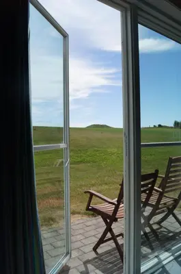 a window view of a bench looking out at a field at Løgstør Parkhotel in Løgstør