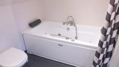 a bathroom with a tub and a toilet and a sink at HotelVFjorden in Lemvig