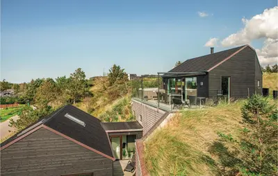a house on top of a hill with a house at Holiday Home Blokhus With Hot Tub Iv in Blokhus