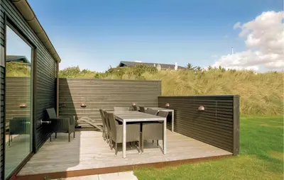 a patio with a table and chairs on a deck at Holiday Home Blokhus With Hot Tub Iv in Blokhus