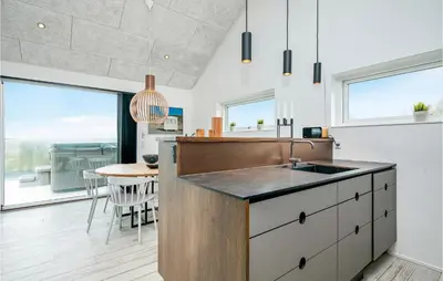 a kitchen with a sink and a table at Holiday Home Blokhus With Hot Tub Iv in Blokhus