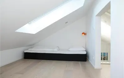 a bedroom with a bed in a attic at Holiday Home Blokhus With Hot Tub Iv in Blokhus