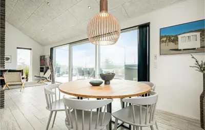 a dining room with a wooden table and chairs at Holiday Home Blokhus With Hot Tub Iv in Blokhus