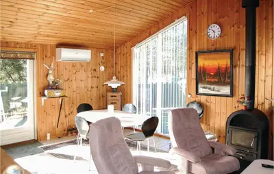 a dining room with a table and chairs and a fireplace at Holiday Home Pandrup With Hot Tub V in Pandrup