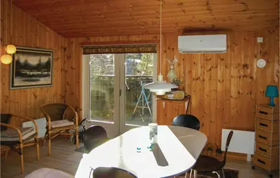 a room with wooden walls and a table and chairs at Holiday Home Pandrup With Hot Tub V in Pandrup