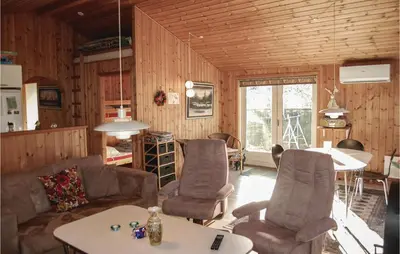 a living room with a couch and chairs and a table at Holiday Home Pandrup With Hot Tub V in Pandrup