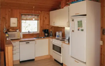a kitchen with white appliances and a white refrigerator at Holiday Home Pandrup With Hot Tub V in Pandrup