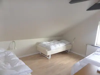 a room with two beds and a bed frame in a attic at Harboøre Hotel in Harboør