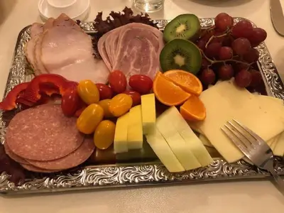 a tray of meats and cheese and fruit on a table at Harboøre Hotel in Harboør