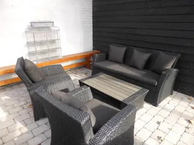 a patio with two chairs and a table and a couch at Harboøre Hotel in Harboør