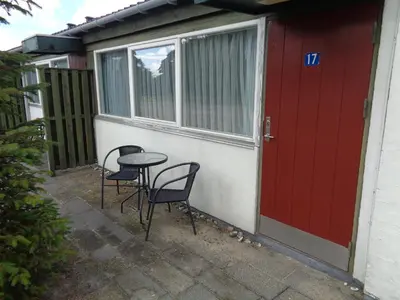 a table and chairs in front of a house with a red door at Hotel St. Binderup in Store Binderup