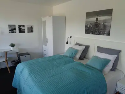 a bedroom with a bed with a blue comforter at Hotel St. Binderup in Store Binderup