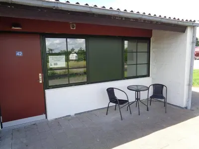 two chairs and a table in front of a building at Hotel St. Binderup in Store Binderup