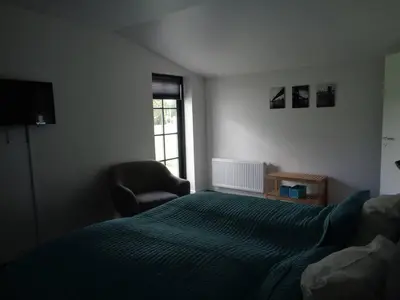 a bedroom with a bed and a chair and a window at Hotel St. Binderup in Store Binderup