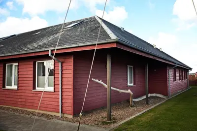 a red house with a black roof at Danhostel Thyborøn in Thyborøn