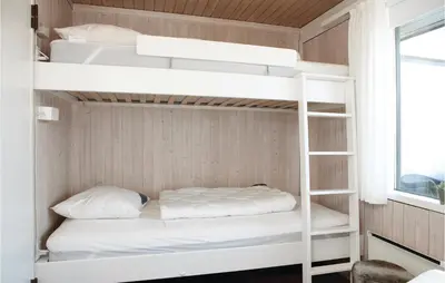 two bunk beds in a small room with a window at Holiday Home Pandrup With Fireplace Ii in Pandrup