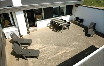 a patio with chairs and tables on a building at Holiday Home Pandrup With Fireplace Ii in Pandrup