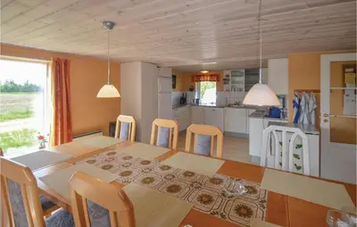 a kitchen and dining room with a table and chairs at Holiday Home Veslos With Fireplace I in Højstrup