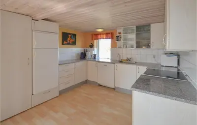 a kitchen with white cabinets and a counter top at Holiday Home Veslos With Fireplace I in Højstrup