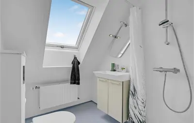 a white bathroom with a shower and a sink at Klitrosen in Harboør