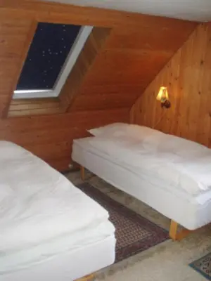 two beds in a room with a window at Strandhuset Holiday Home in Glyngøre