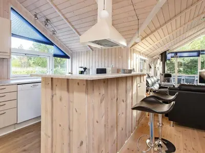 a kitchen with wood paneling and a large island in a tiny house at 7 person holiday home in Løgstør-By Traum in Trend