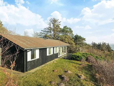 a black and white house on top of a hill at Secluded Beach Retreat - By Traum Ferienwohnungen in Lihme