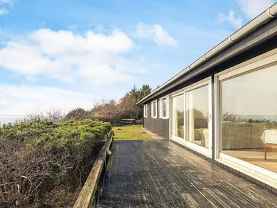 a house with a wooden walkway next to a building at Secluded Beach Retreat - By Traum Ferienwohnungen in Lihme