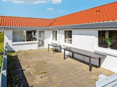 a bench in front of a building with an orange roof at 8 person holiday home in Frøstrup-By Traum in Lild Strand