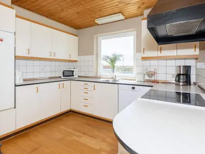 a kitchen with white cabinets and a large window at 8 person holiday home in Frøstrup-By Traum in Lild Strand