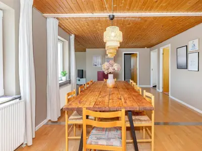 a dining room with a wooden table and chairs at 8 person holiday home in Frøstrup-By Traum in Lild Strand