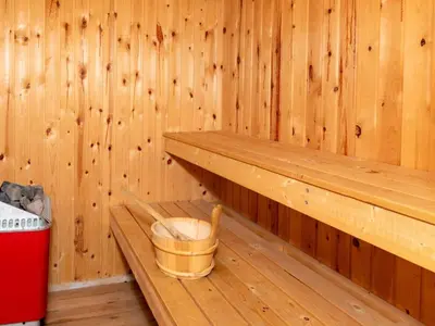 a wooden sauna with a bucket and a trash can at 8 person holiday home in Frøstrup-By Traum in Lild Strand
