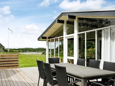 a patio with a wooden table and chairs at 10 person holiday home in Højslev-By Traum in Lund