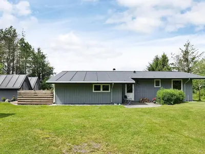 a house with a gray roof and a yard at 10 person holiday home in Højslev-By Traum in Lund