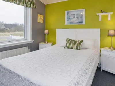 a bedroom with a white bed and a yellow wall at 8 person holiday home in Løgstør-By Traum in Trend