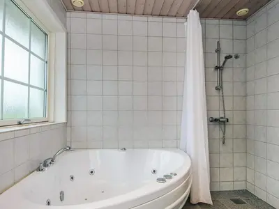a white bath tub in a bathroom with a window at 12 person holiday home in Harboøre-By Traum in Vrist